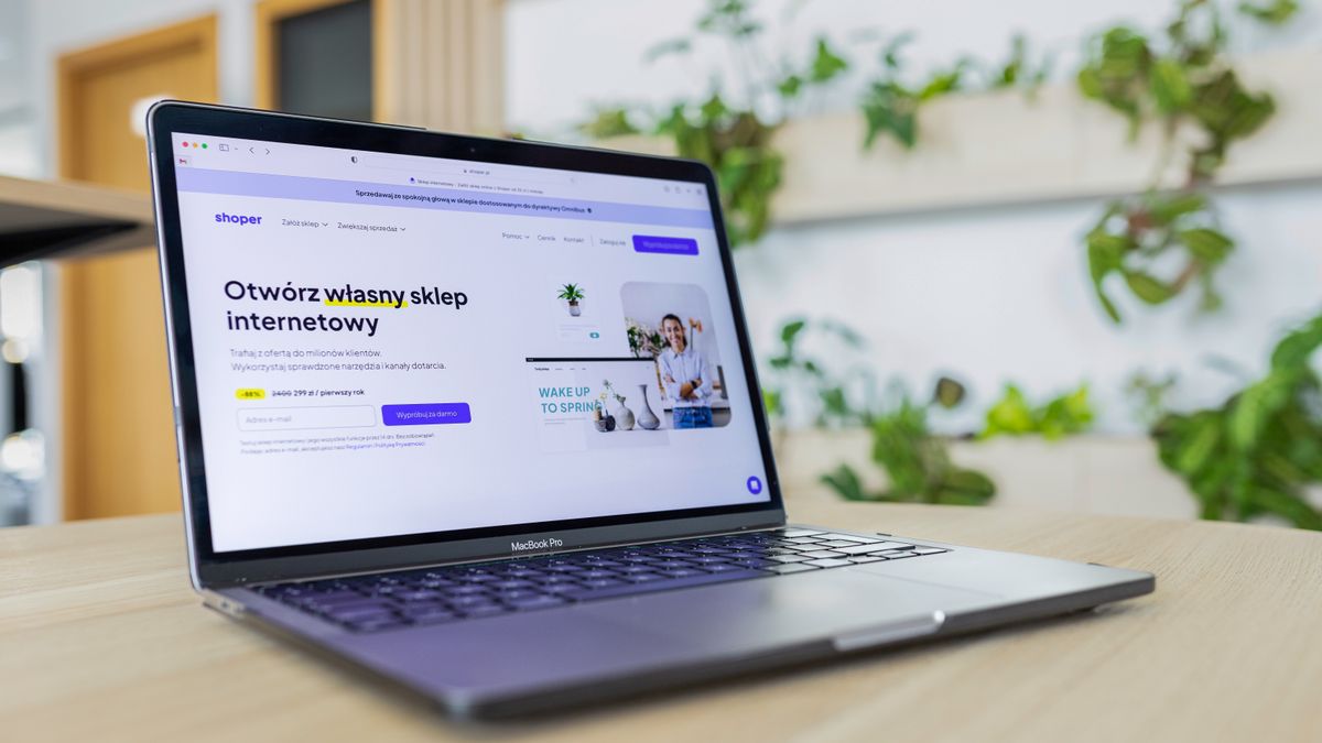 Close-up of a laptop with an open e-commerce website, surrounded by modern office decor
