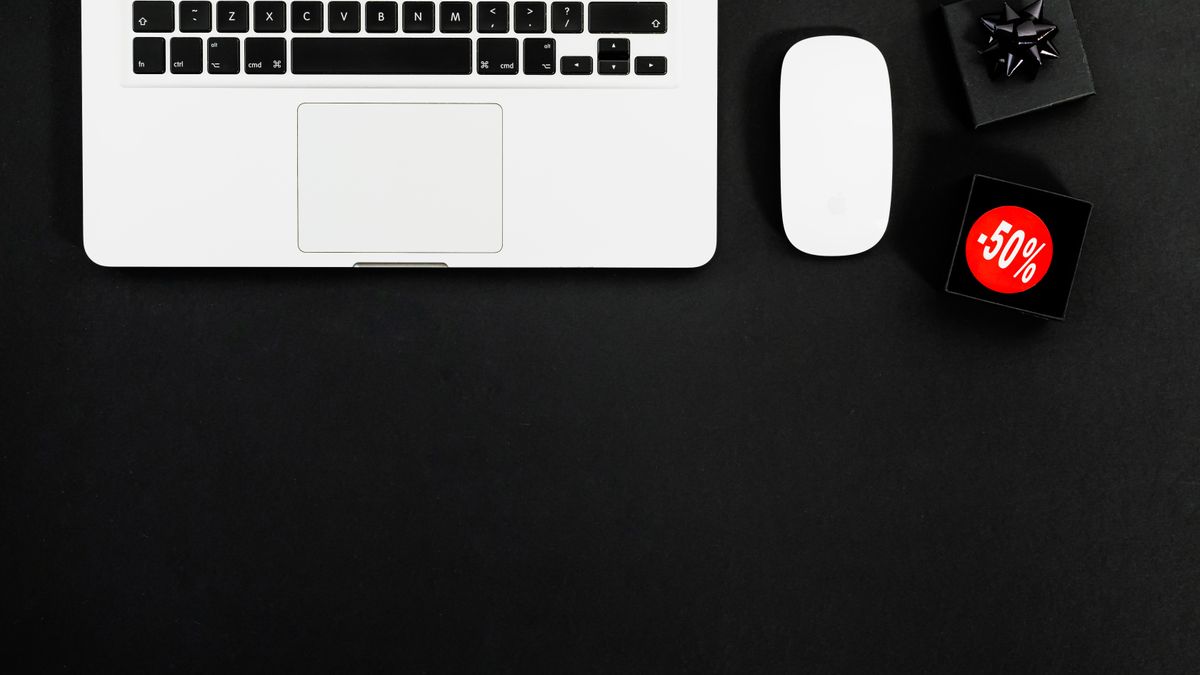 Minimalist flat lay featuring a laptop and shopping items with 50% sale tags